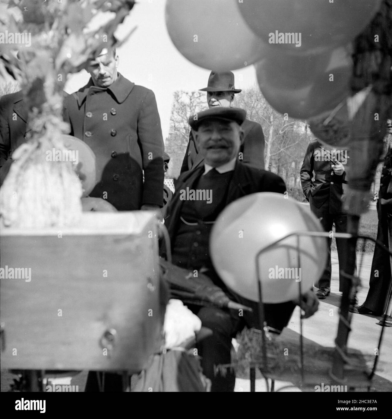 Deux photographies d'une scène où des enfants reçoivent des ballons dans un parc parisien non identifié en 1945.Une photo montre trois parents, trois enfants debout et un bébé partiellement obscurci dans une poussette.L'autre photo montre un ballon-homme souriant (légèrement hors foyer) entouré par plusieurs hommes.Certains hommes portent des uniformes. Banque D'Images