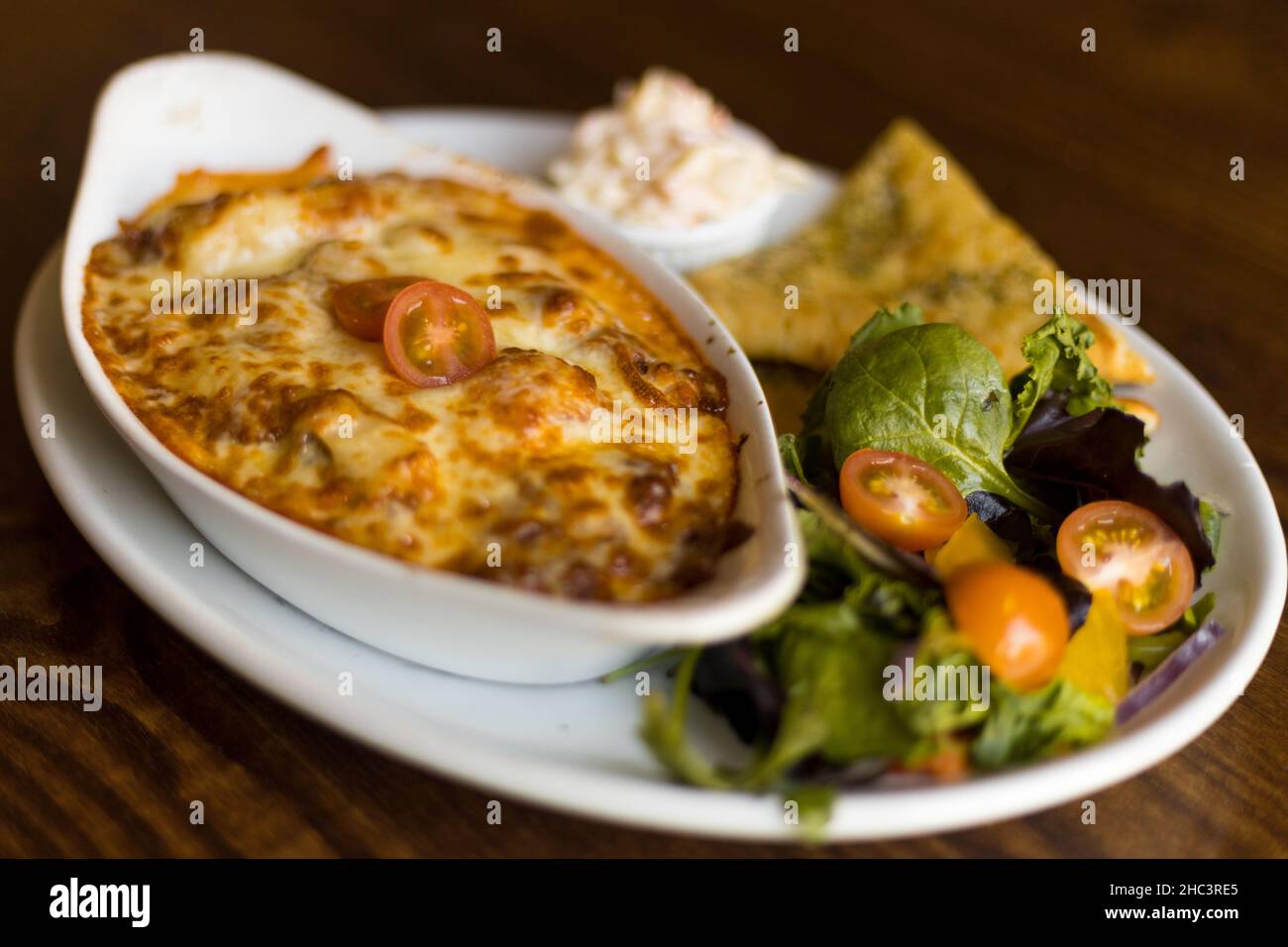 Lasagnes de bœuf Aberdeen Angus avec pain plat à l'ail - salade et coleslaw Banque D'Images