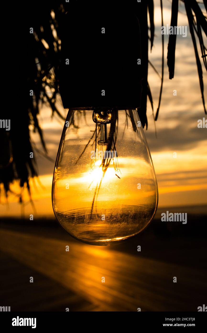 Belle photo d'une ampoule lumineuse avec la mer au coucher du soleil en arrière-plan Banque D'Images