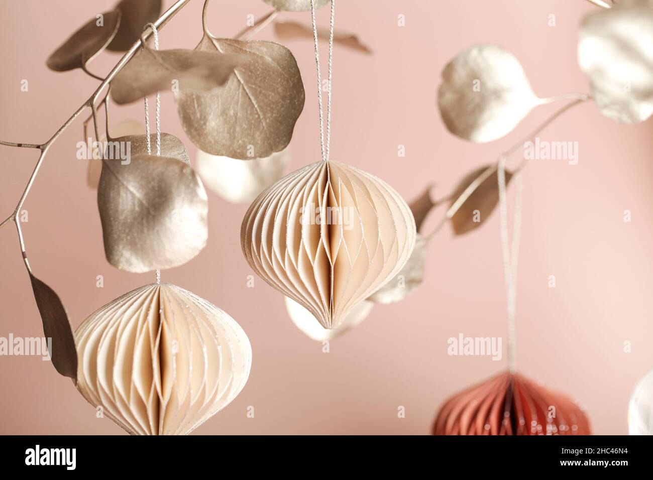 Décoration de Noël en papier nid d'abeille sur branche dorée sur fond beige .Vacances saisonnières, carte de vœux, vacances écologiques. Banque D'Images