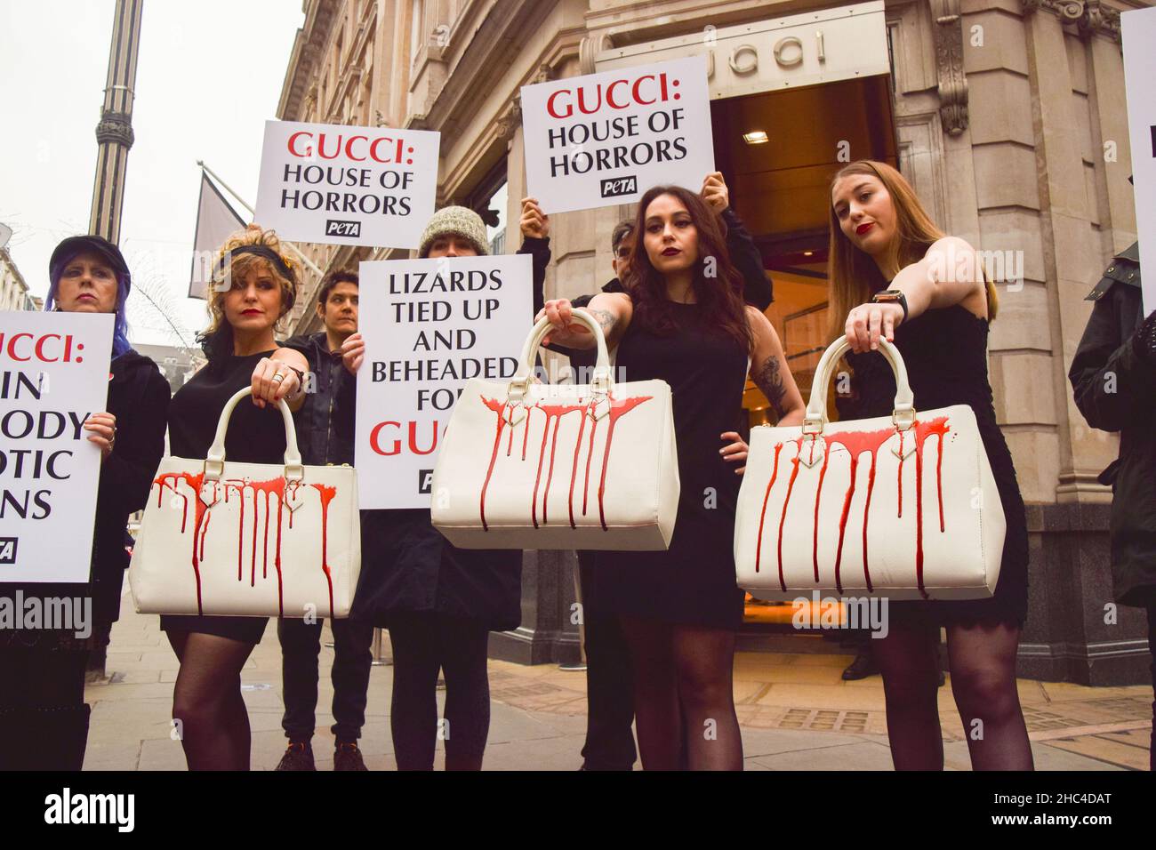 Londres, Royaume-Uni 23rd décembre 2021.Les militants du PETA se sont rassemblés devant le magasin Gucci de Bond Street et ont organisé une « passerelle » avec des sacs à main éclatés de faux sang pour protester contre l'utilisation de peaux de lézard dans les produits de Gucci.L'enquête de PETA a montré que les fournisseurs de peau de lézard tombent bien en dessous des normes de bien-être des animaux et causent d'énormes souffrances pour les animaux. Banque D'Images