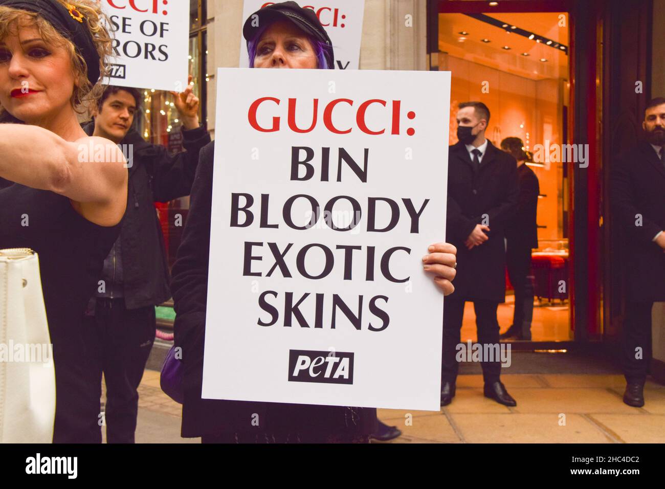 Londres, Royaume-Uni 23rd décembre 2021.Les militants du PETA se sont rassemblés devant le magasin Gucci de Bond Street et ont organisé une « passerelle » avec des sacs à main éclatés de faux sang pour protester contre l'utilisation de peaux de lézard dans les produits de Gucci.L'enquête de PETA a montré que les fournisseurs de peau de lézard tombent bien en dessous des normes de bien-être des animaux et causent d'énormes souffrances pour les animaux. Banque D'Images