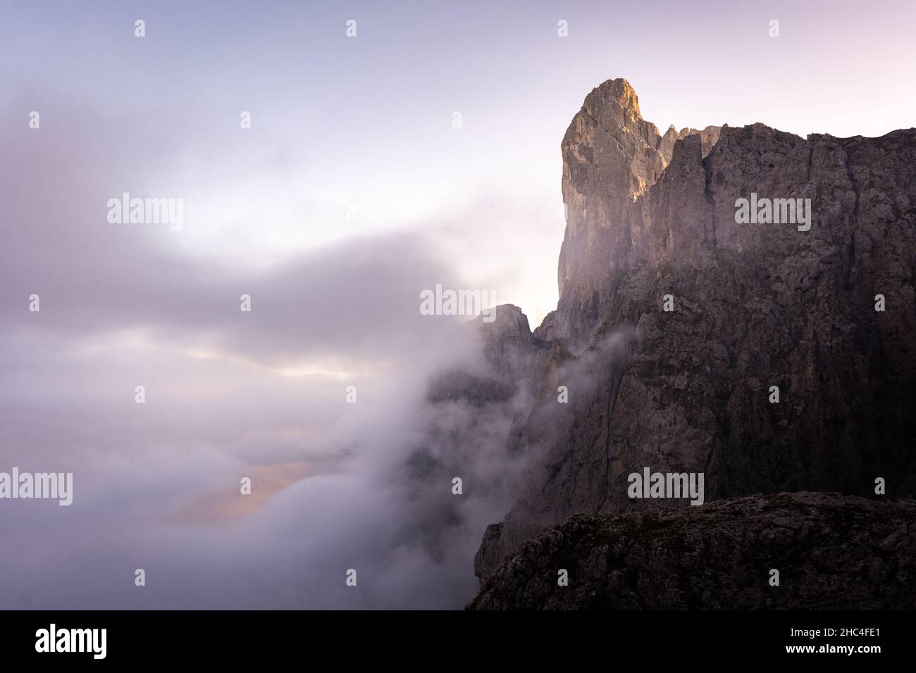 bord d'une falaise dans les montagnes de pâle di san martino dans les dolomites entouré de nuages Banque D'Images