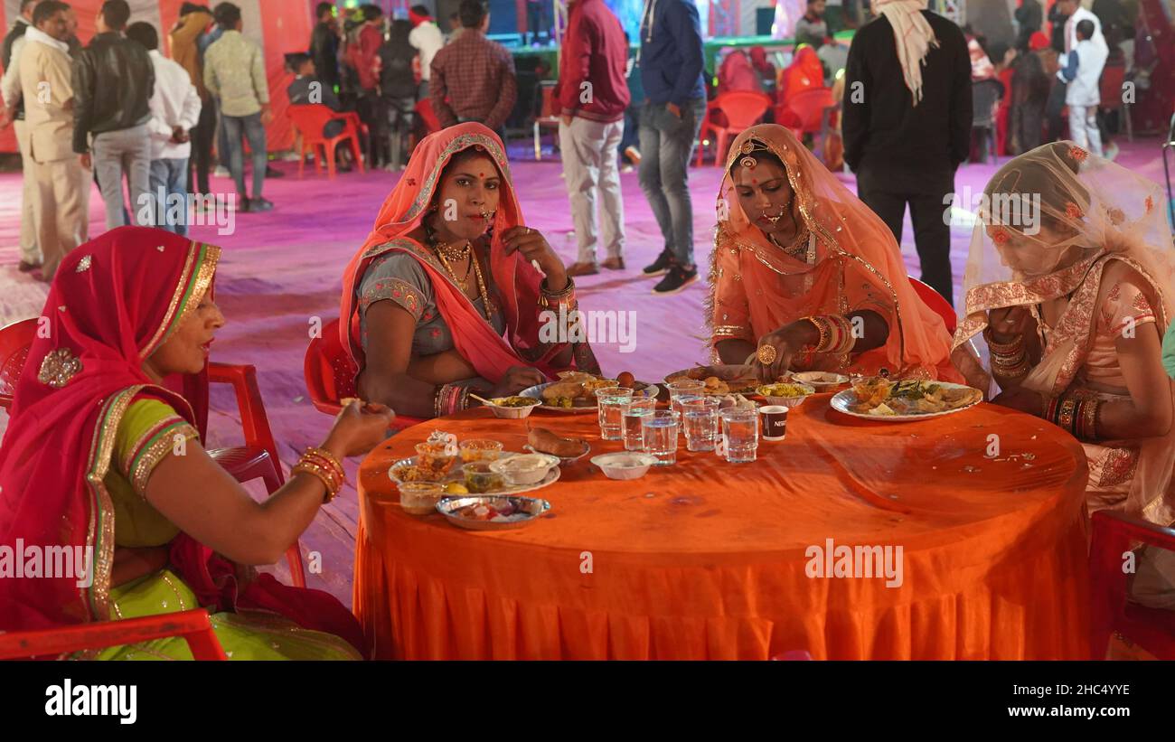 21 novembre 2021 Reengus, Rajasthan, Inde.Rajasthani femmes mangeant de la nourriture à une fonction de mariage. Banque D'Images