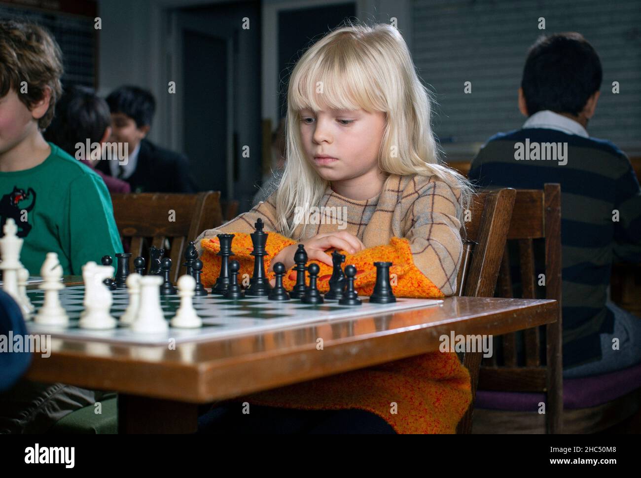 Jeux intelligents.Un enfant joue aux échecs. Fille et un échiquier.Stratégie.Pensée logique. Petite fille joue aux échecs Banque D'Images