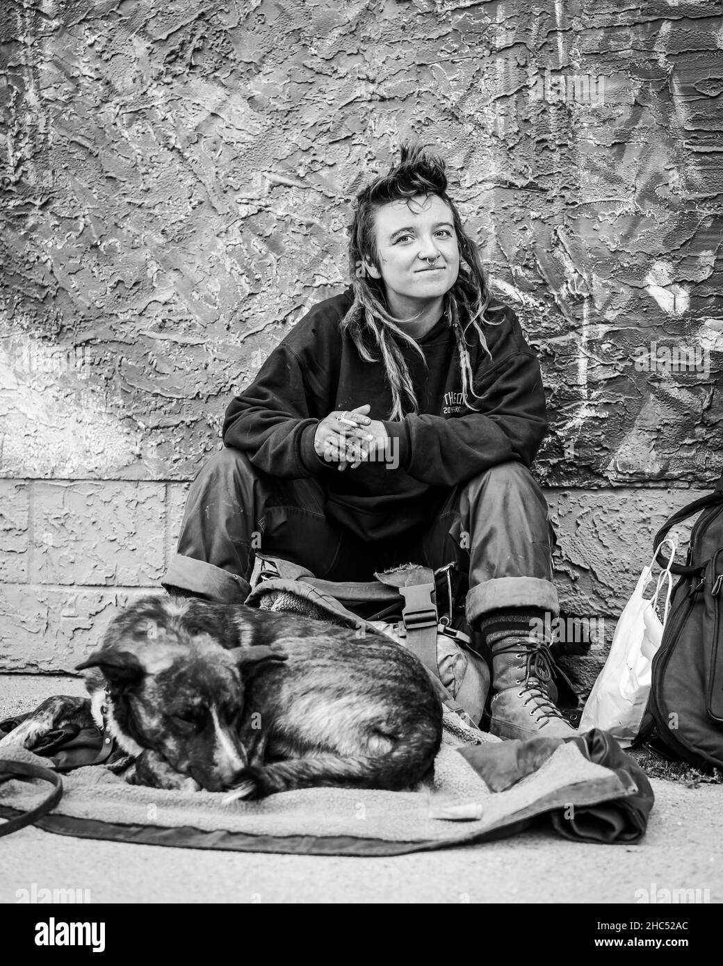 Photo en échelle de gris d'une femme sans abri et de son chien dans une rue de Moose Jaw, Canada Banque D'Images Photo en échelle de gris d'une femme sans abri et de son chien dans une rue de Moose Jaw, Canada Banque D'Images