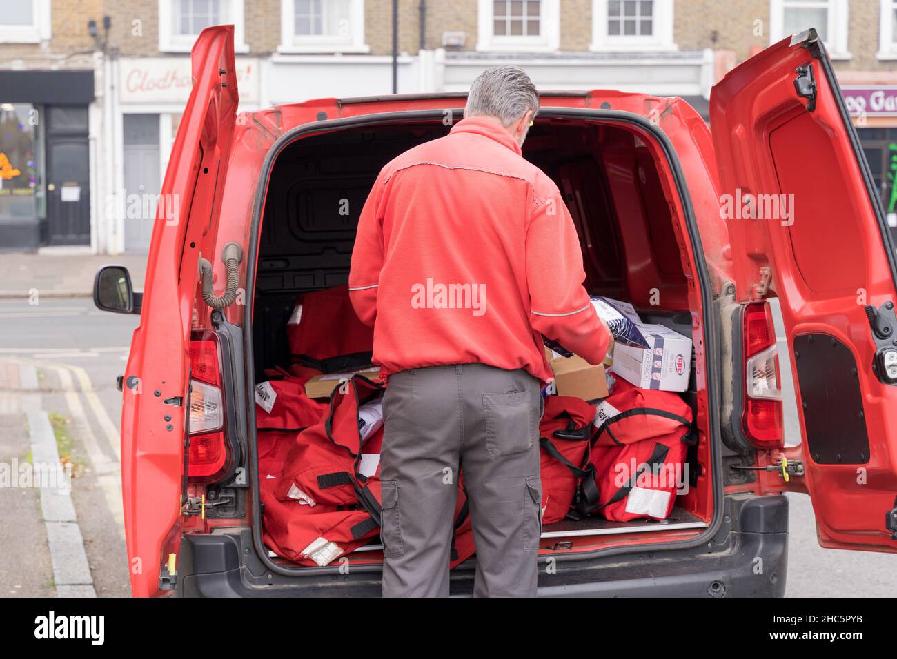 Santa Postman ouvre les portes arrière pour livrer et distribuer des cadeaux de Noël à la communauté locale du sud de Londres Angleterre Royaume-Uni Banque D'Images