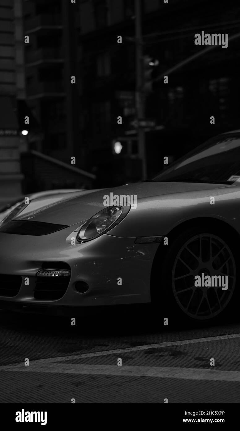 Prise de vue verticale en niveaux de gris d'une voiture Porsche 911 Turbo à Manhattan, New York la nuit Banque D'Images