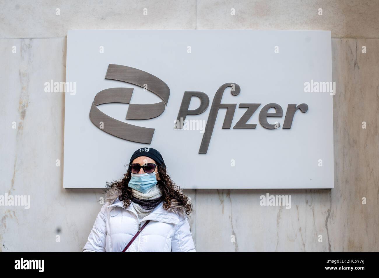 New York, États-Unis.22nd décembre 2021.Une femme portant un masque se tient à l'extérieur du bâtiment Pfizer de Manhattan.Pfizer a produit le vaccin ARNM pour prévenir les maladies graves de la COVID-19.Crédit : SOPA Images Limited/Alamy Live News Banque D'Images
