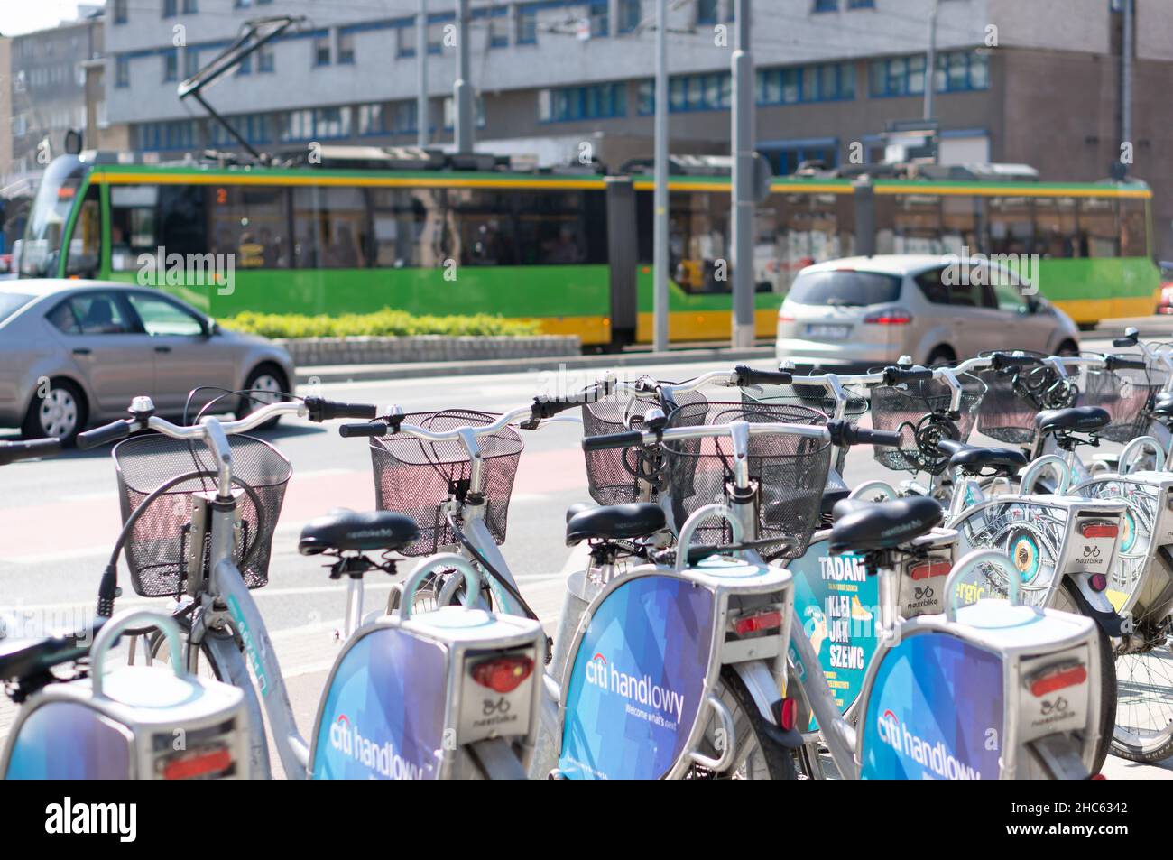 La rangée de vélos de marque Nextbike est verrouillée sur des poteaux sur un trottoir dans le centre-ville, Poznan Banque D'Images