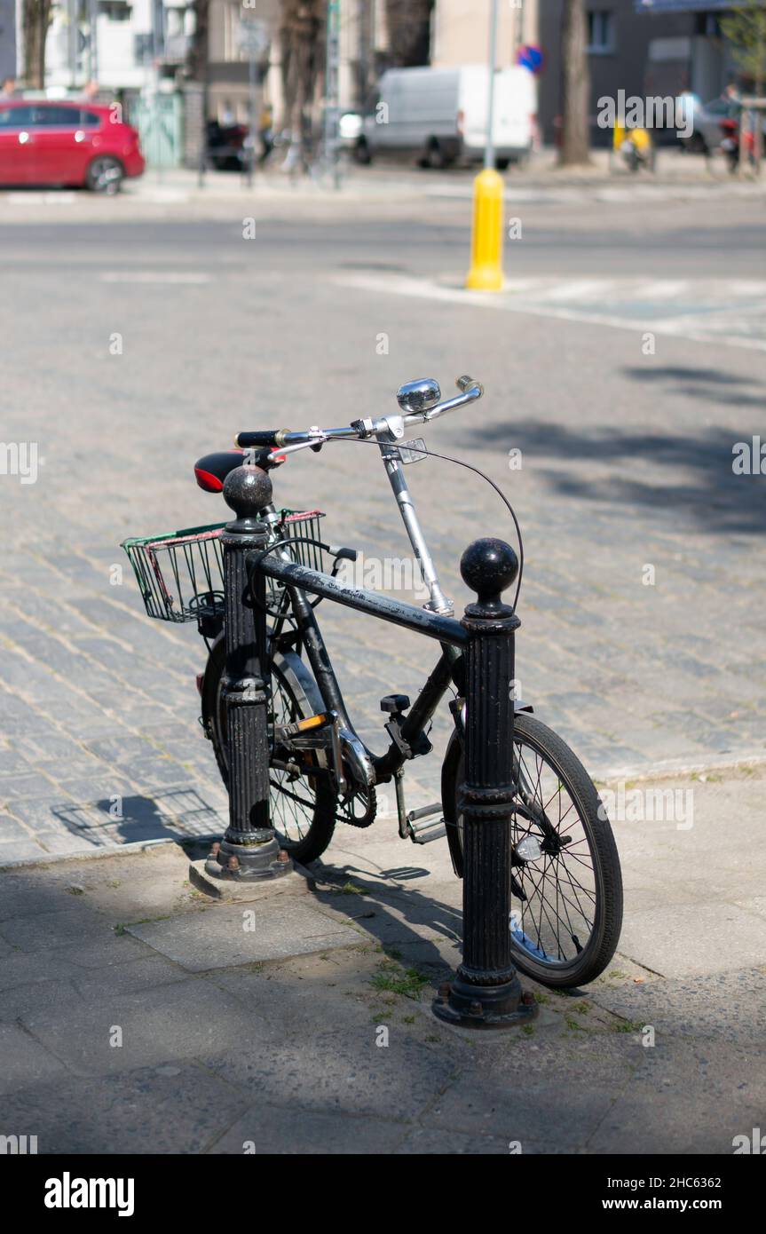 Petit vélo verrouillé sur une barrière dans le centre-ville, Poznan, Pologne Banque D'Images