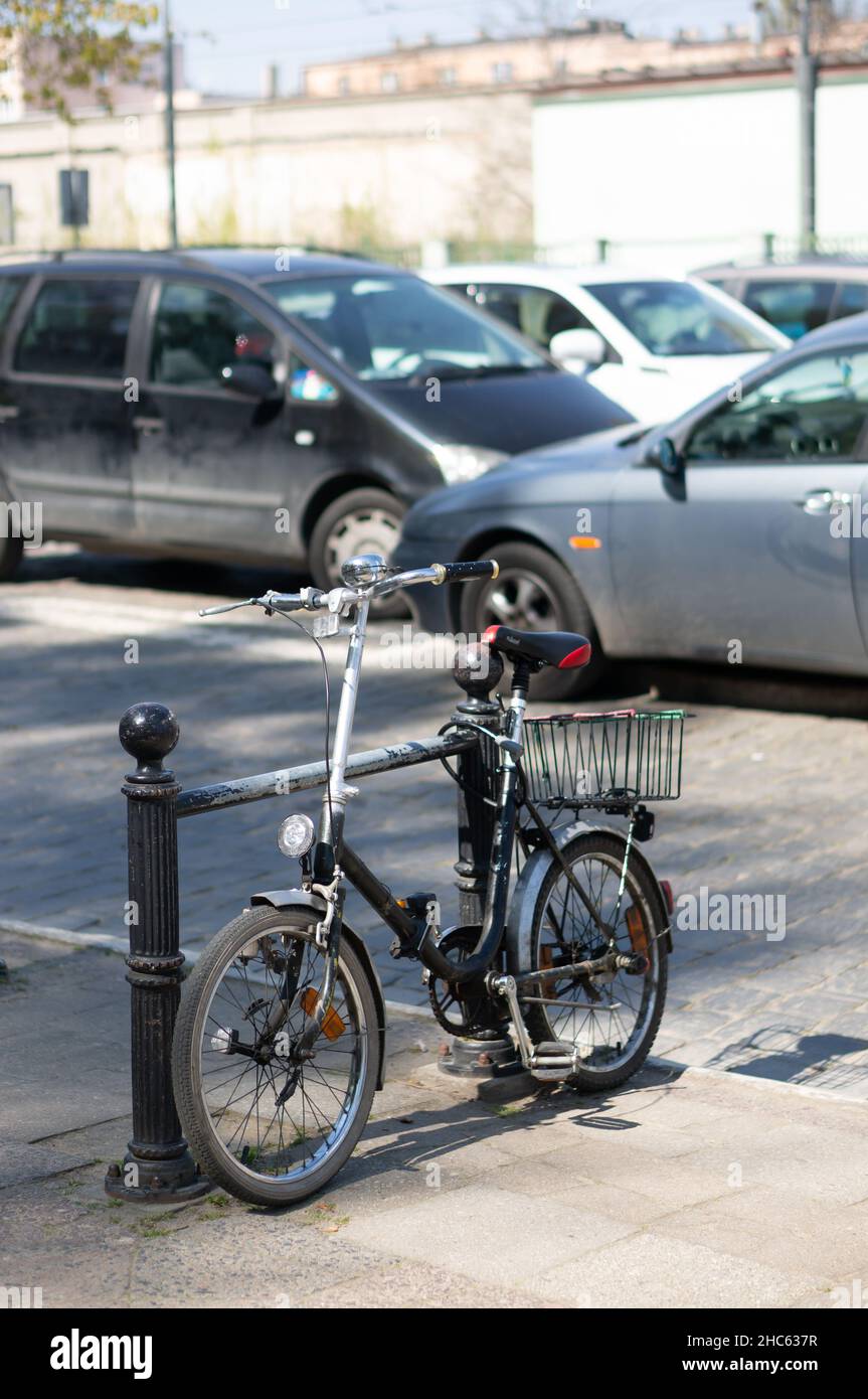 Petit vélo verrouillé sur une barrière près d'une rue dans le centre-ville, Poznan, Pologne Banque D'Images