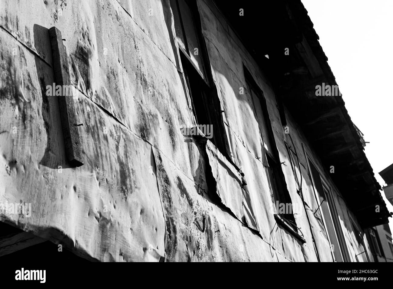 Gros plan à angle bas d'une façade de bâtiment en pierre ancienne en niveaux de gris Banque D'Images