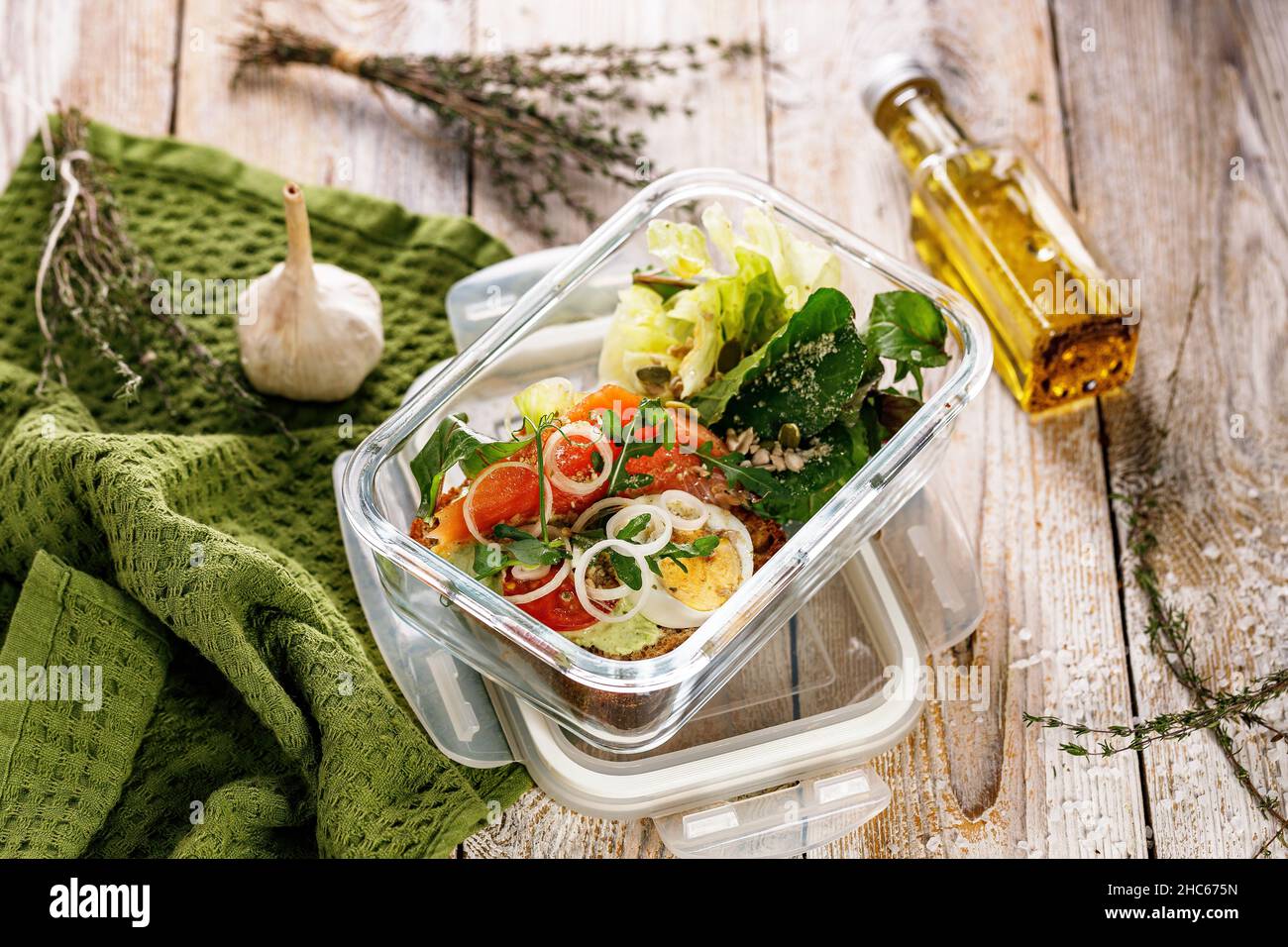Déjeuner délicieux et sain avec filet de saumon dans une boîte à lunch en verre.Salade avec saumon fumé, fromage doux, œufs, oignons et légumes.Fruits de mer Banque D'Images