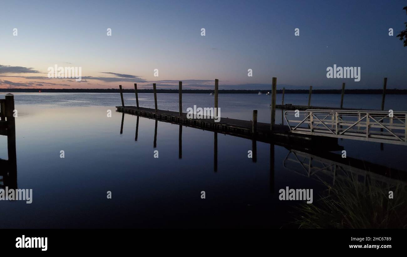 Vue panoramique d'un quai en bois sur la côte de la mer au coucher du soleil Banque D'Images