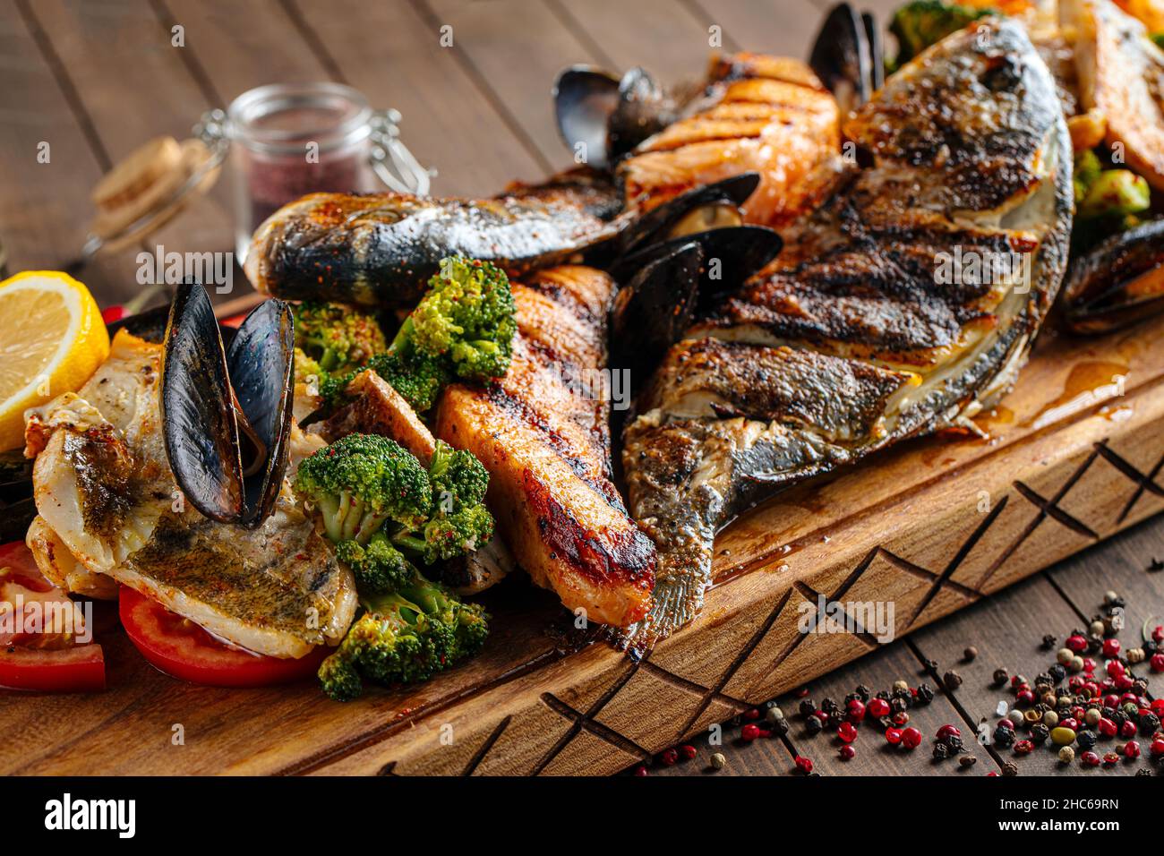 Assortiment de poissons grillés sur une table de service en bois Banque D'Images Assortiment de poissons grillés sur une table de service en bois Banque D'Images