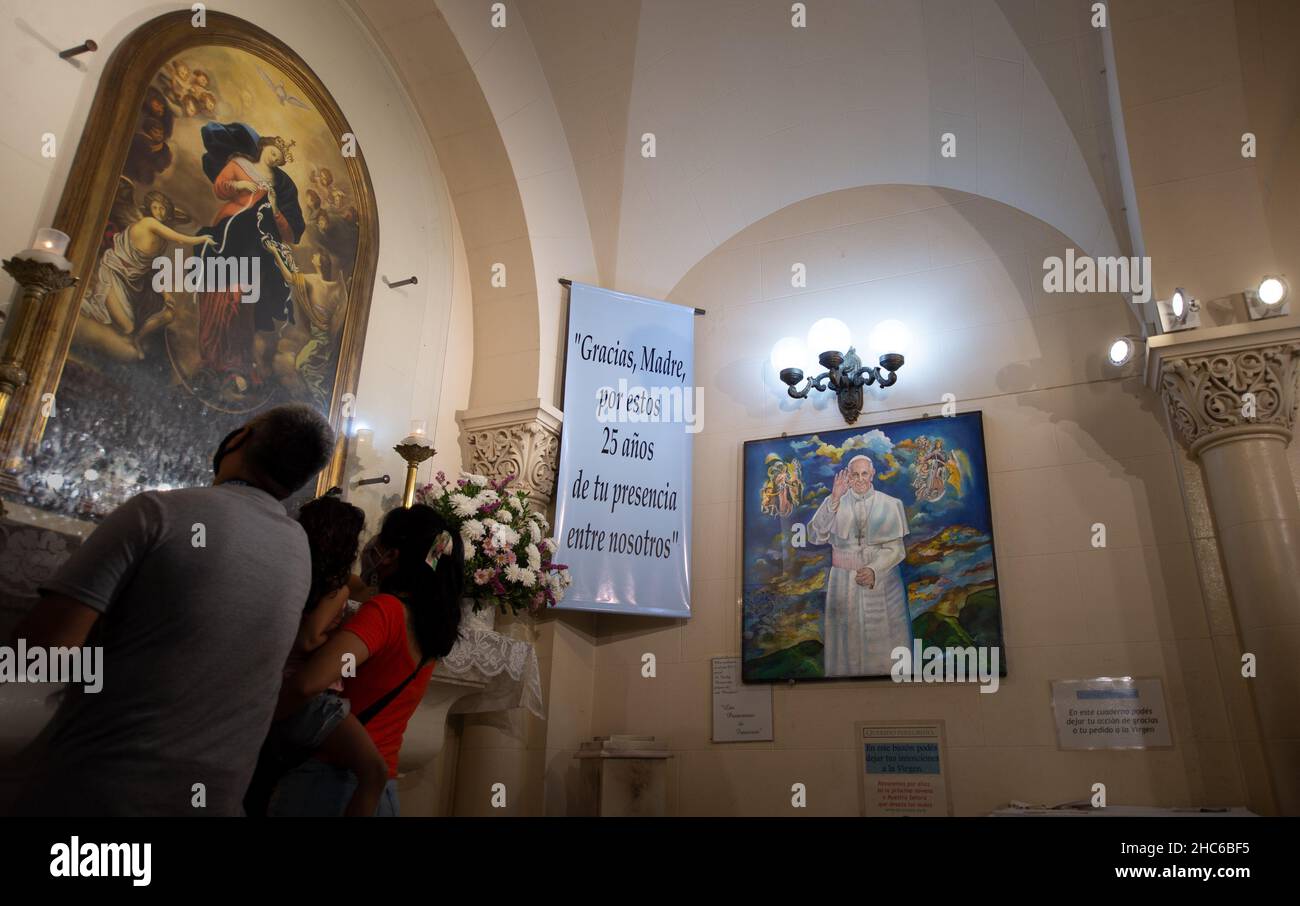 Buenos Aires, Argentine.08th décembre 2021.Les gens prient dans l'église de San Jose del Talar devant une réplique de l'image de Marie Knoted Redeemer par l'artiste Schmidtner.L'image a été apportée d'Allemagne en 1980s par le prêtre Bergoglio, aujourd'hui pape de l'Église catholique.La réplique est suspendue à côté d'une peinture représentant le Pape François et est visitée par de nombreux fidèles le 8 décembre de chaque année.Credit: Florencia Martin/dpa/Alay Live News Banque D'Images