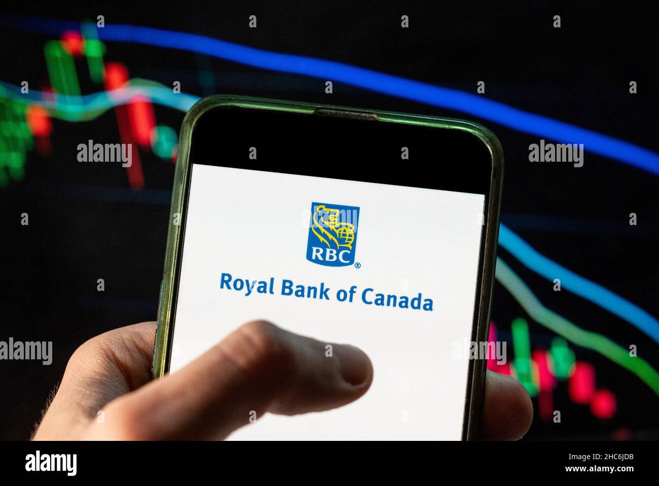 Dans cette illustration, la multinationale canadienne de services financiers, le logo RBC de la Banque Royale du Canada, est affiché sur un smartphone avec un graphique de l'indice boursier économique en arrière-plan. Banque D'Images