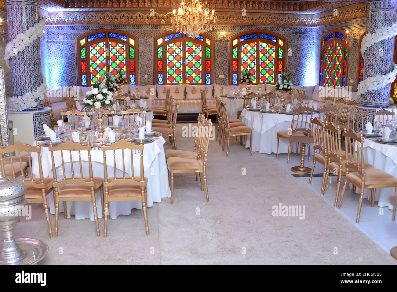 Salle de mariage marocaine.Tables et chaises mur marocain doré avec