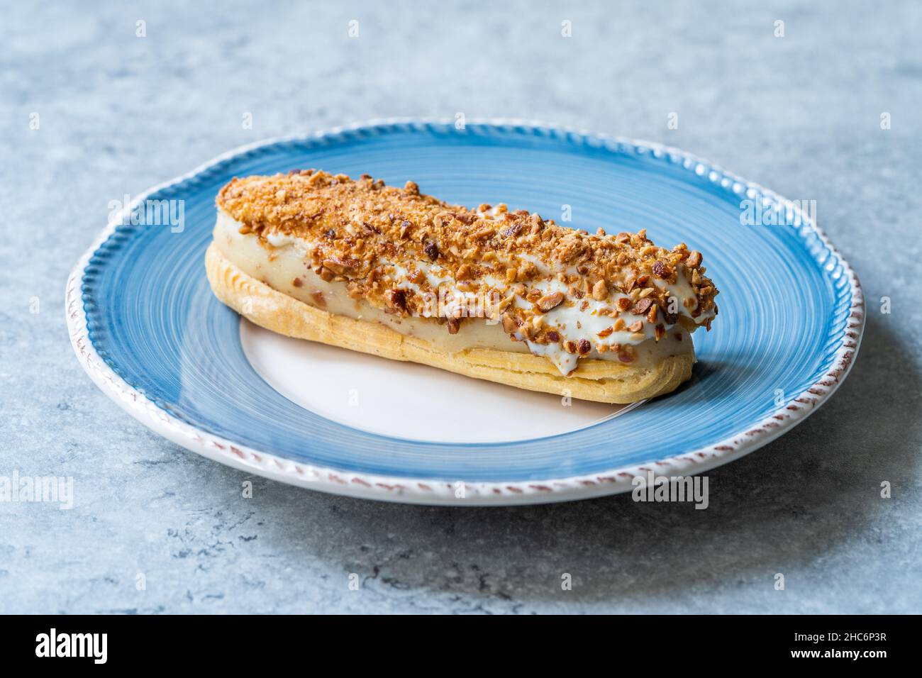 Eclair avec crème et poudre d'amande.Dessert français traditionnel.Prêt à manger. Banque D'Images