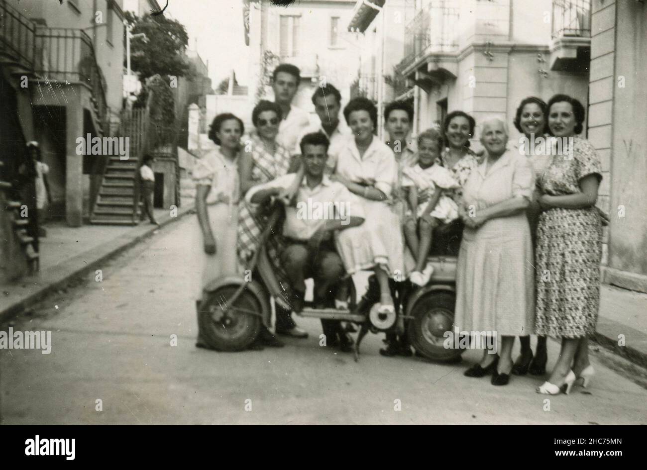 Grand groupe familial avec un cyclomoteur Lambretta sur la route pour la photo, Italie 1953 Banque D'Images