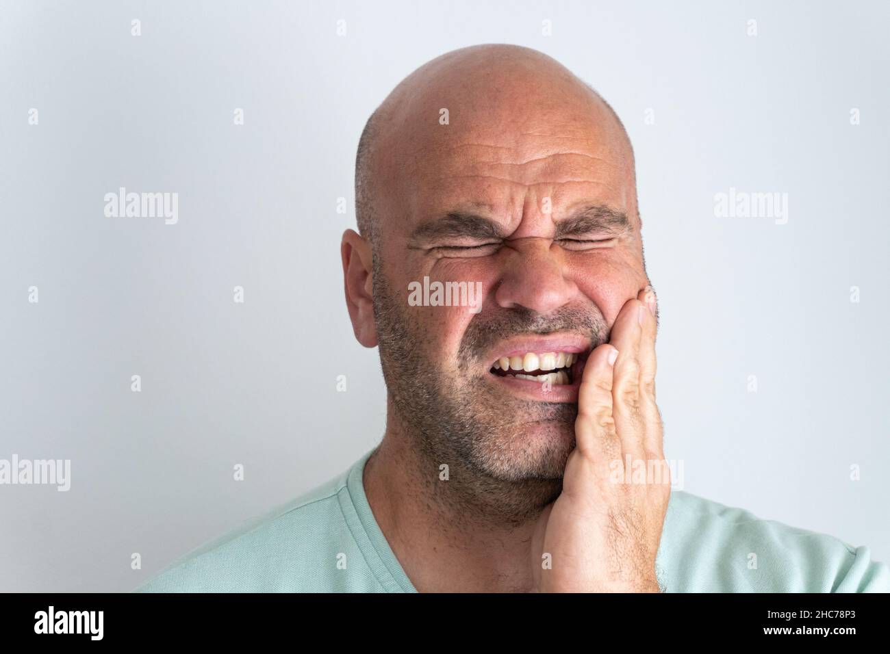 De chauve, barbu caucasien homme gesturant un mal de dents. Banque D'Images