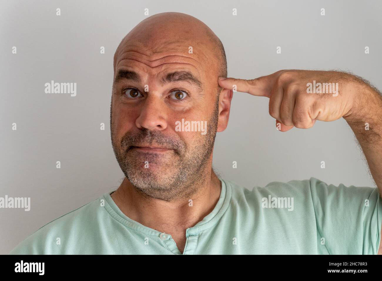 Gros plan sur le visage d'un homme caucasien à barbe chauve, en faisant des gestes et en accusant avec l'index Banque D'Images