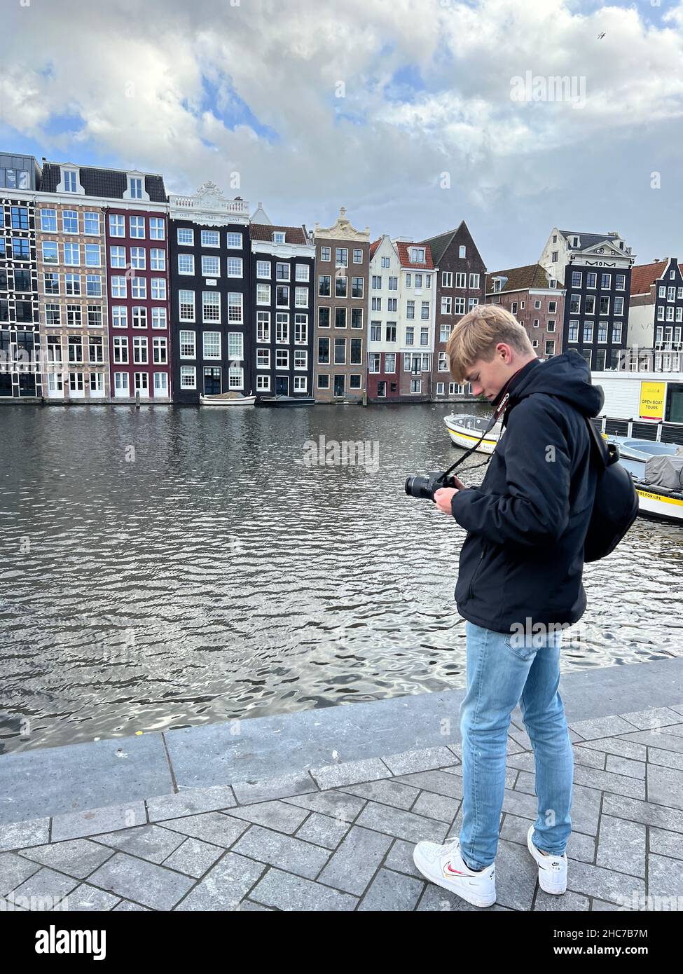 Jeune photographe prenant des photos près du lac en face de bâtiments colorés à Amsterdam Banque D'Images