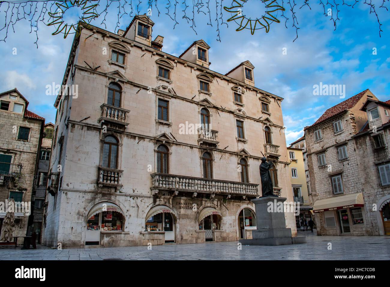 Le ciel bleu ajoute de la lumière à l'ancienne architecture de Split Croatie. Des arches, des piliers en pierre et un design complexe vous permettront de découvrir la magnifique ville balnéaire Banque D'Images