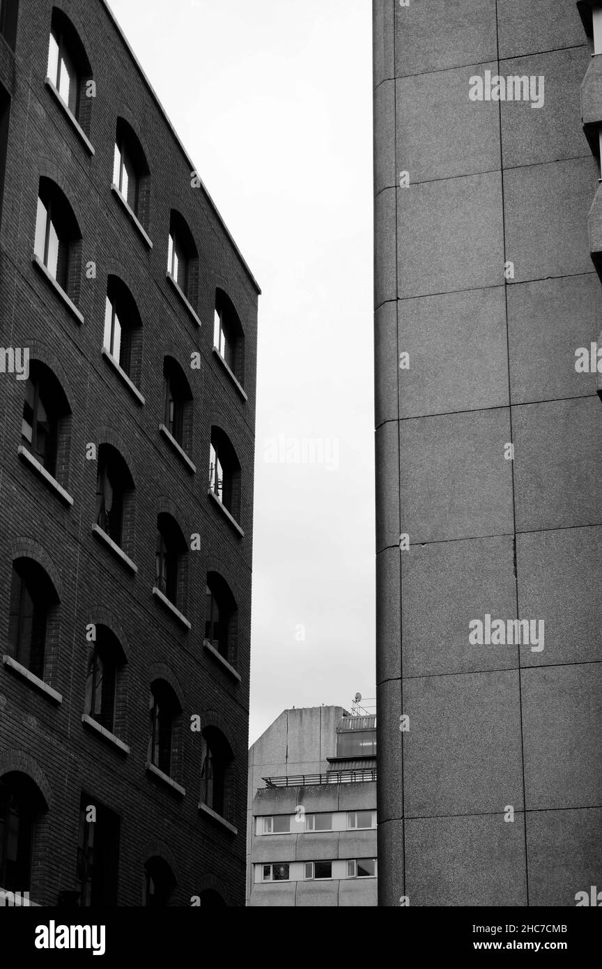 Vue verticale des bâtiments monochromes avec une réflexion du ciel sans nuages dans les fenêtres Banque D'Images