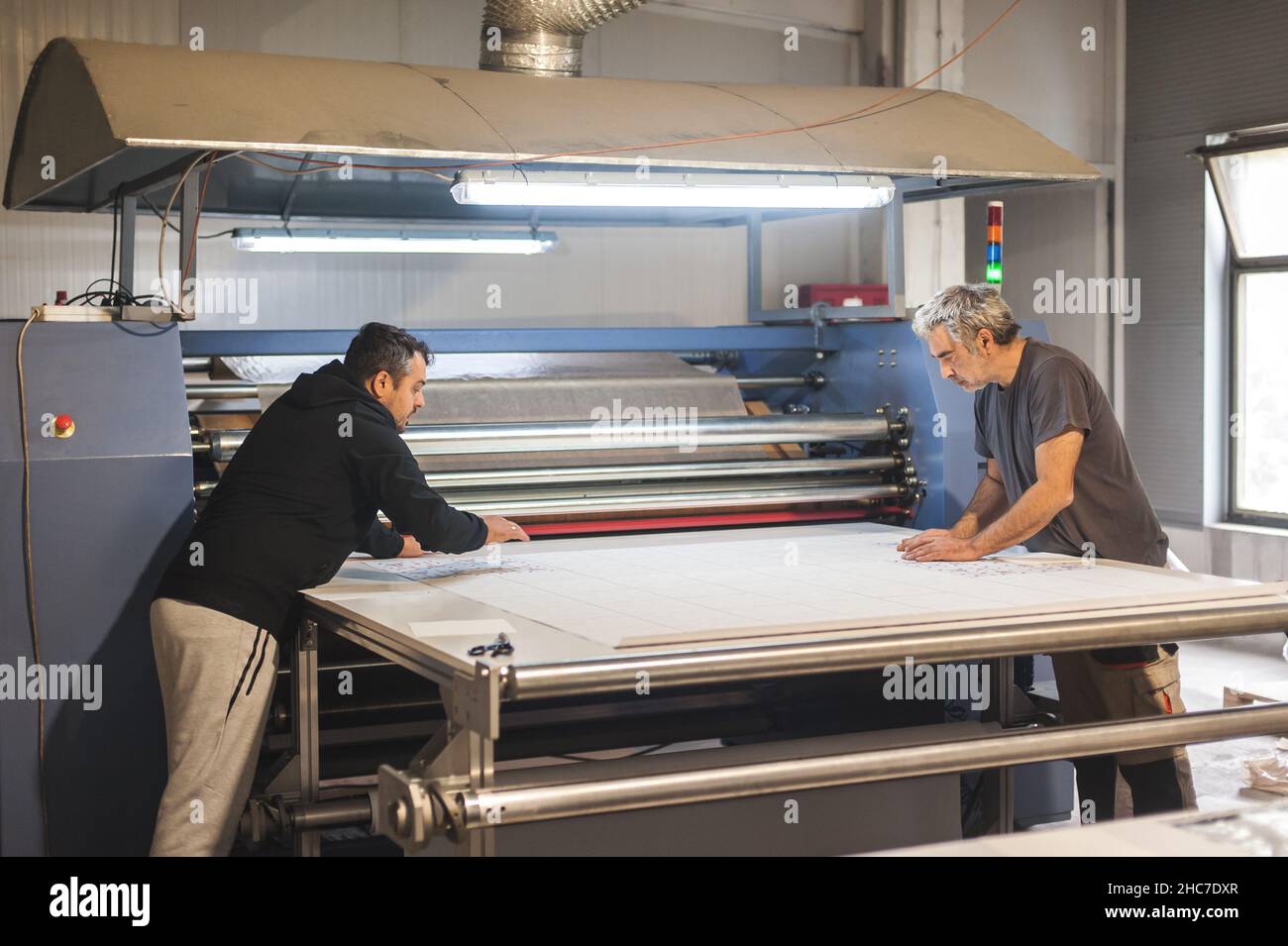 Deux techniciens opérateurs travaillent sur une grande machine d'impression  de presse à chaleur à rouleaux de sublimation textile industriel de qualité  supérieure dans l'atelier d'impression numérique o Photo Stock - Alamy