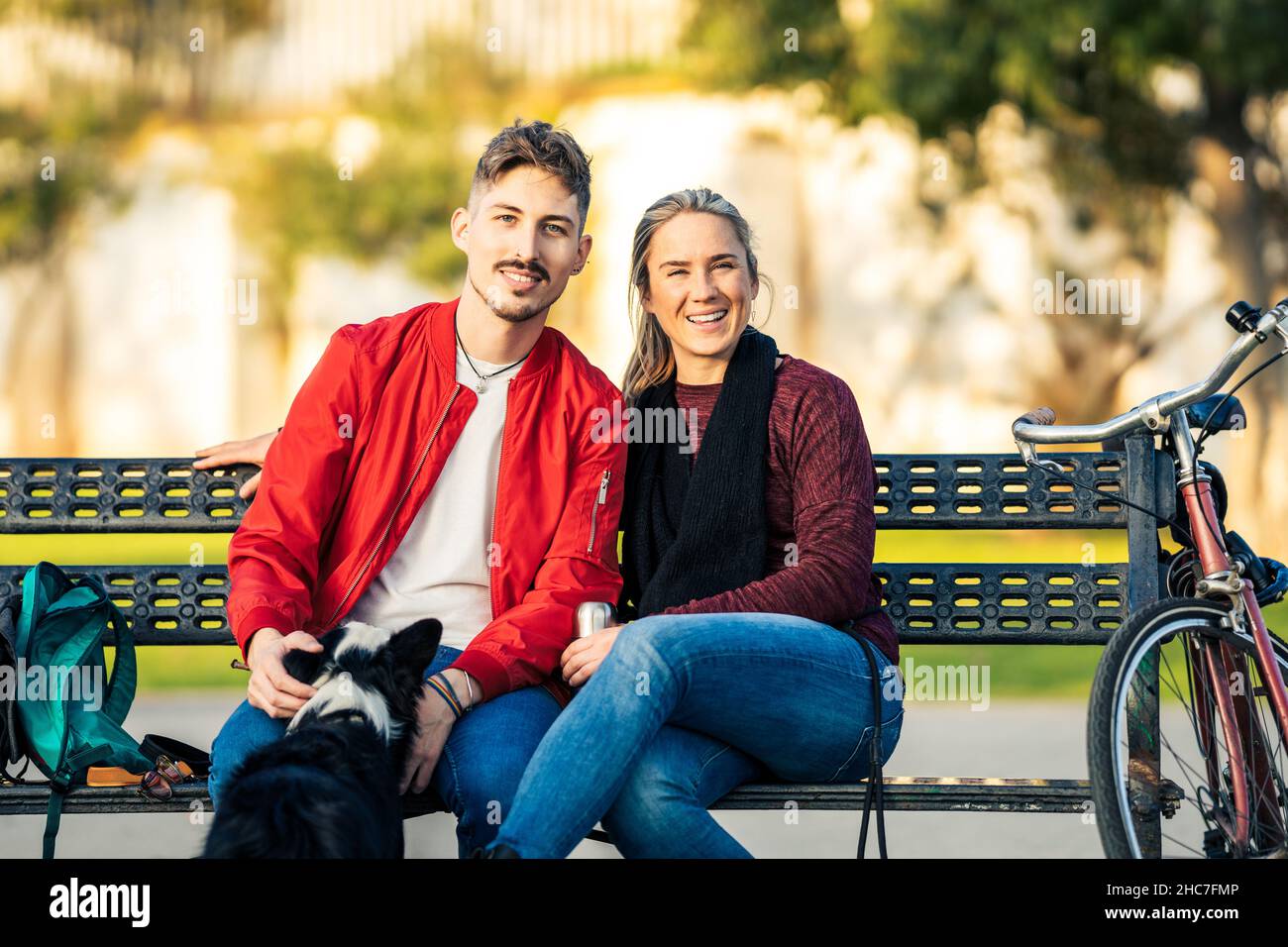 Portrait d'un couple assis sur un banc avec un chien Banque D'Images