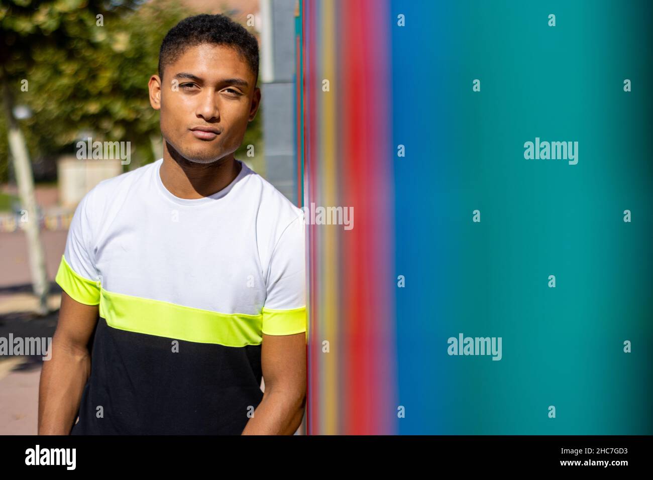portrait d'un jeune latino sur la rue appuyé contre un mur Banque D'Images