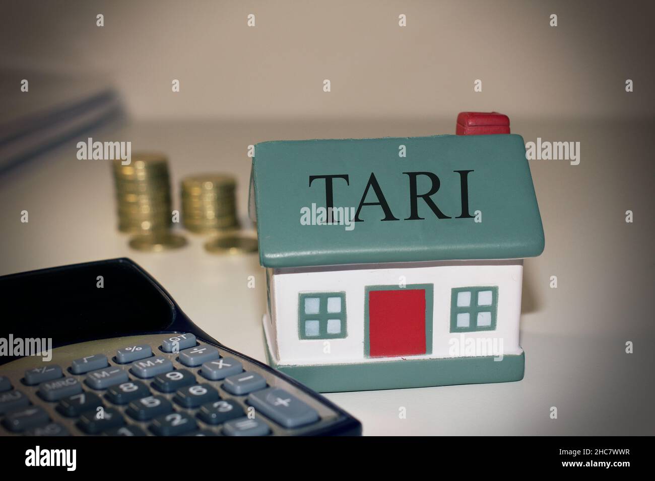 Maison avec un calcul et des pièces en euros avec le texte 'tari' concept de la taxe italienne Banque D'Images