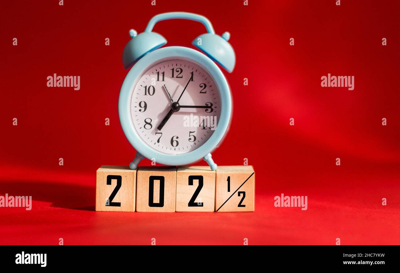 Cubes en bois modifiés de 2021 à 2022 avec horloge.Arrière-plan rouge avec espace de copie. Banque D'Images