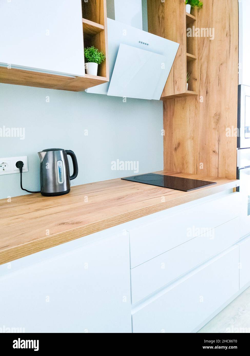 Cuisine blanche intérieure scandinave avec hotte sur comptoir en bois Banque D'Images