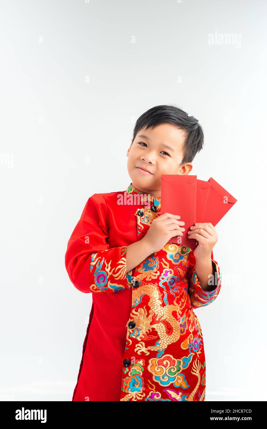 Un petit garçon vietnamien qui tient des enveloppes rouges pour Tet. Le mot signifie le double bonheur. C'est le cadeau en lunar nouvelle année ou Tet Holiday sur isoler backgro Banque D'Images