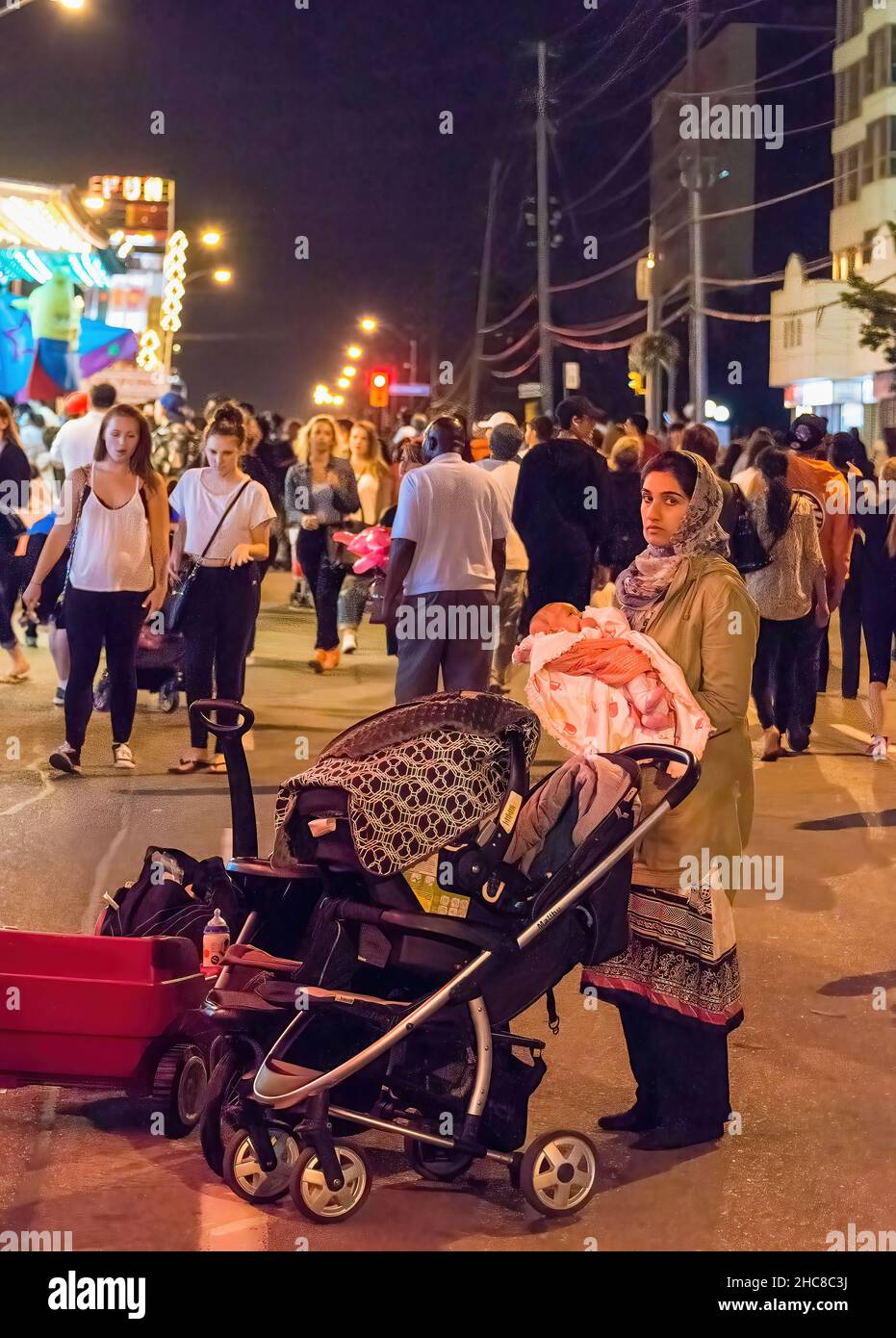 Toronto, Canada - le 4 juillet 2015 : une femme musulmane tient bébé pendant la nuit au festival Taste of Lawrence Banque D'Images