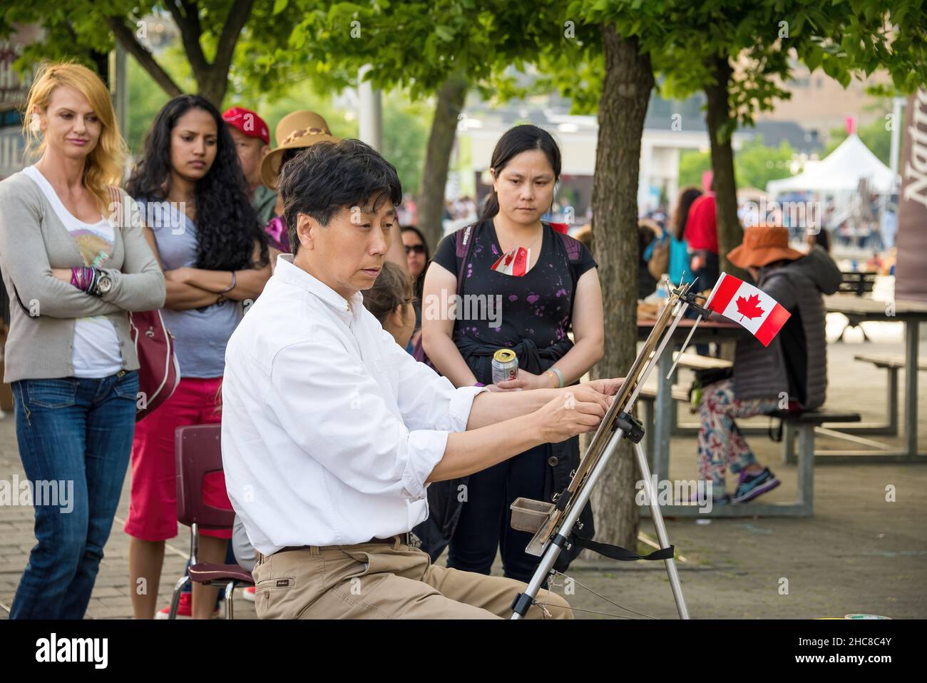 Toronto, Canada - le 1 juillet 2015 : les célébrations de la fête du Canada à Toronto Harbourfront.Un artiste asiatique de sexe masculin peint une photo de la rue.Les gens qui regardent moi Banque D'Images