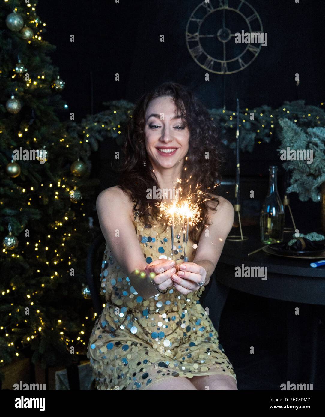 fille en robe d'or avec des sparkers pendant la nouvelle année Banque D'Images