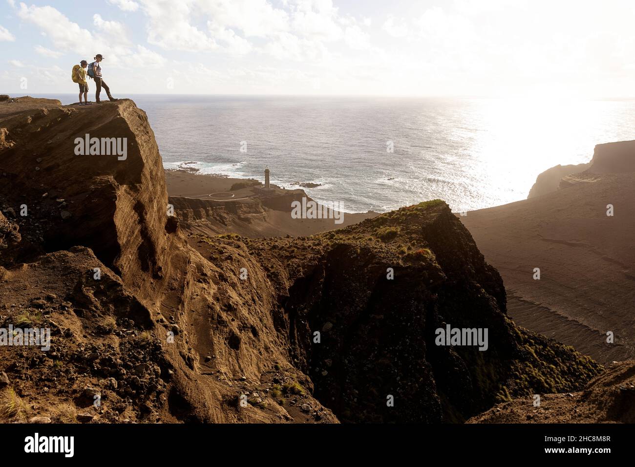 Mère et fils debout sur un point de vue sur le volcan et le phare de Capelinhos, Ponta dos Capelinhos, Faial, îles des Açores, Portugal Banque D'Images