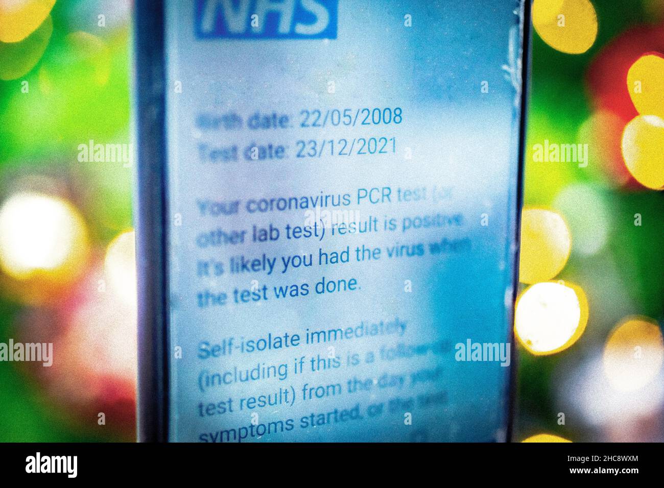 Gros plan du téléphone avec le message positif du test PCR du coronavirus NHS Banque D'Images