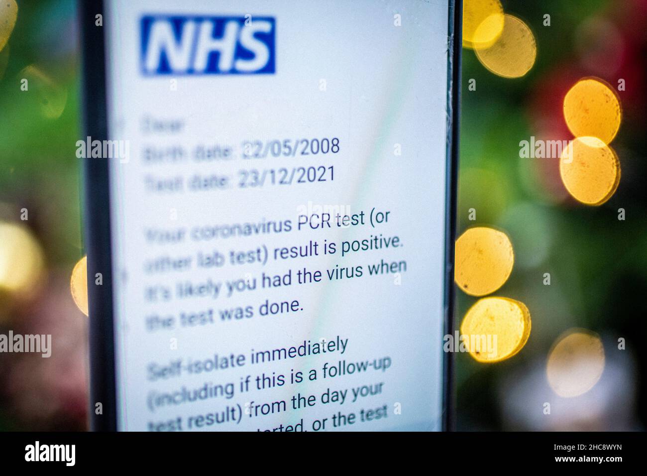 Gros plan du téléphone avec le message positif du test PCR du coronavirus NHS Banque D'Images