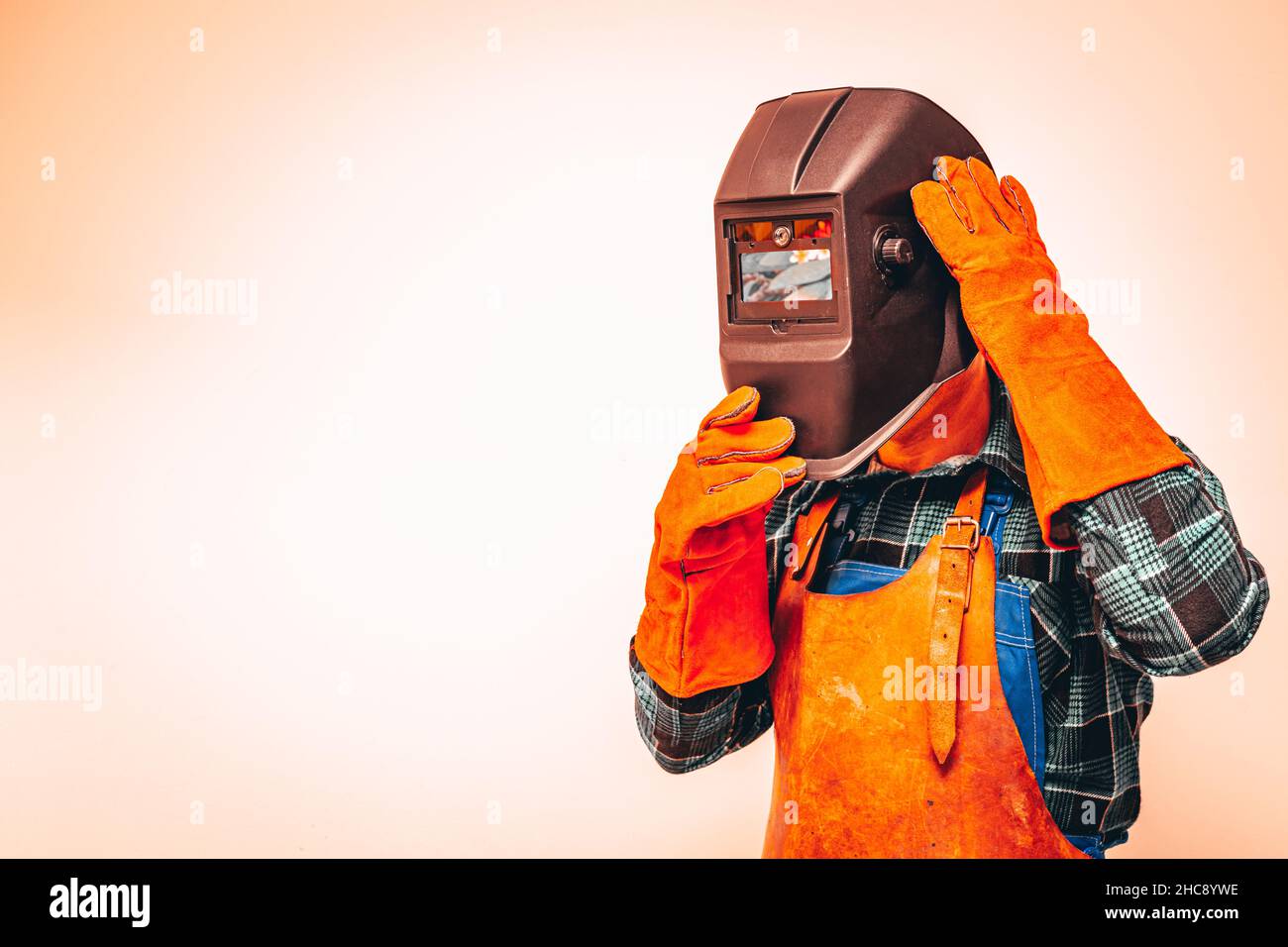 Ouvrier lourd dans une combinaison de protection avec un masque pour protéger les yeux et le visage, couleurs vives, espace pour le texte Banque D'Images