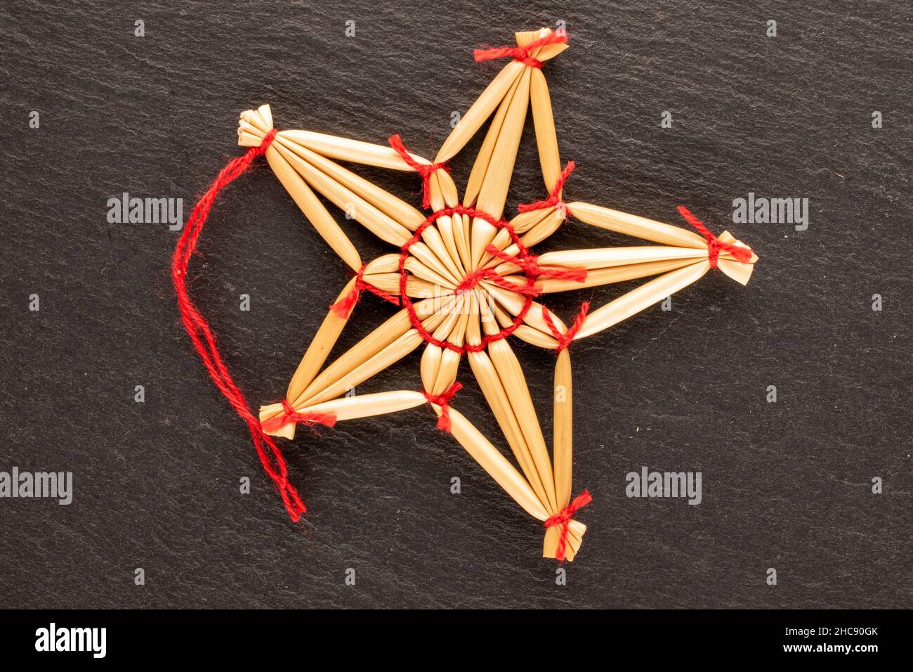 Un jouet de Noël en paille en forme d'étoile sur une pierre d'ardoise, vue rapprochée du dessus. Banque D'Images