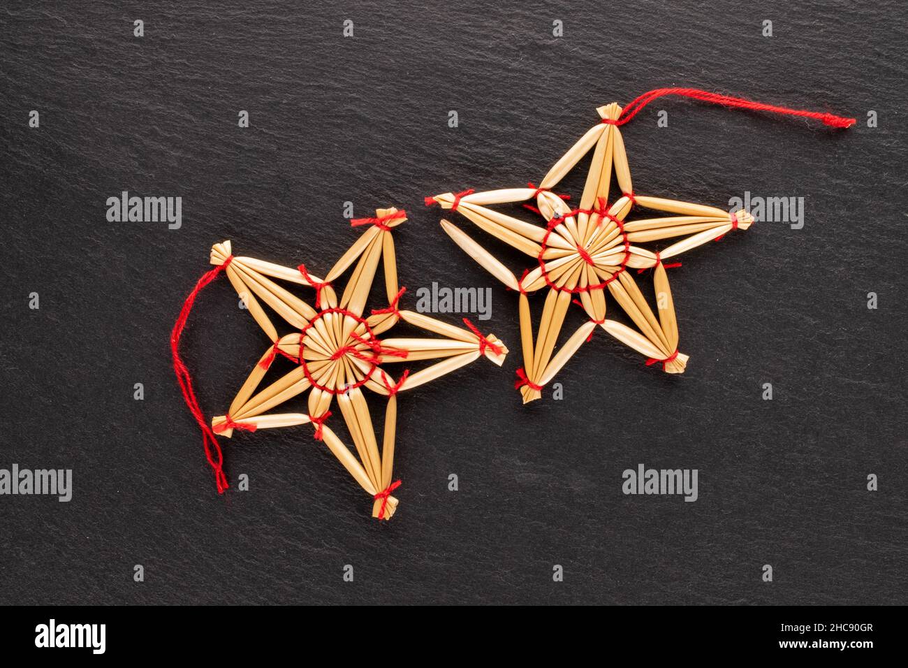 Deux jouets de Noël en paille en forme d'étoile sur une pierre d'ardoise, vue rapprochée du dessus. Banque D'Images