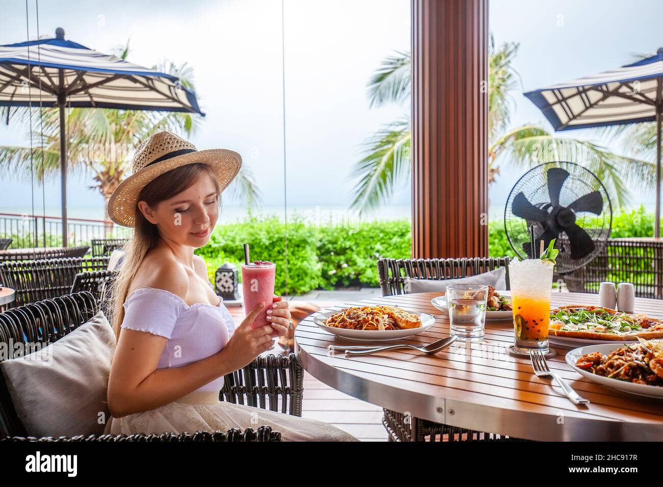 Bonne jeune femme mangeant des pâtes italiennes au restaurant, femme avec de la nourriture au café Banque D'Images