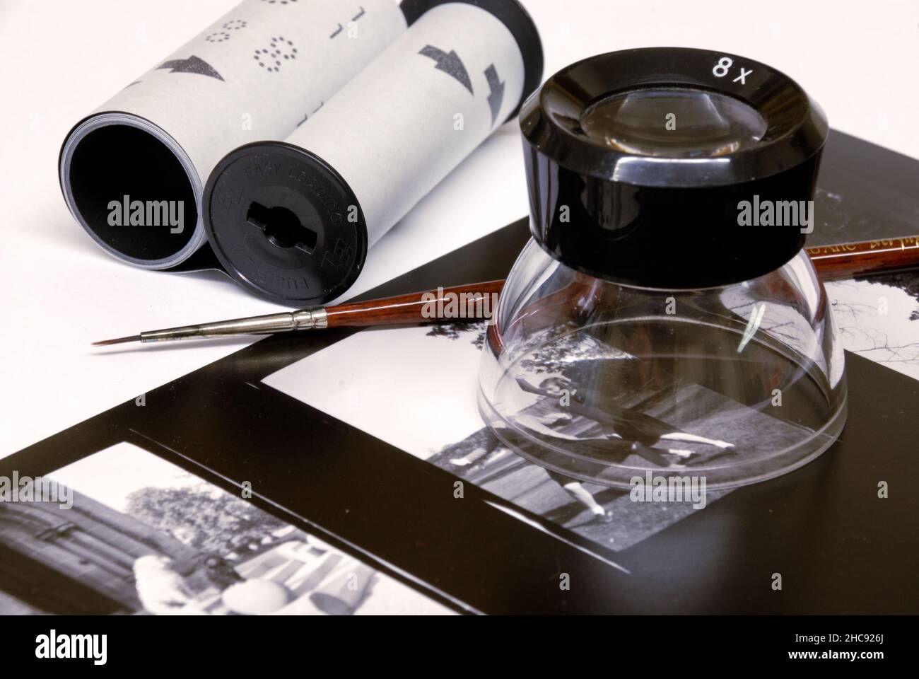 Un rouleau de 120mm avec le film retiré pour le traitement, pinceau à taches, loupe (loupe) et planche contact des négatifs. Banque D'Images