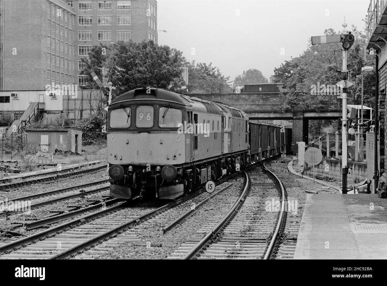 Une paire de locomotives diesel de classe 33 numéros 33008 et 33019 double dirigeant un train de wagons de ballast vides passant les signaux du sémaphore à Kensington Olympia le 15th juillet 1991. Banque D'Images