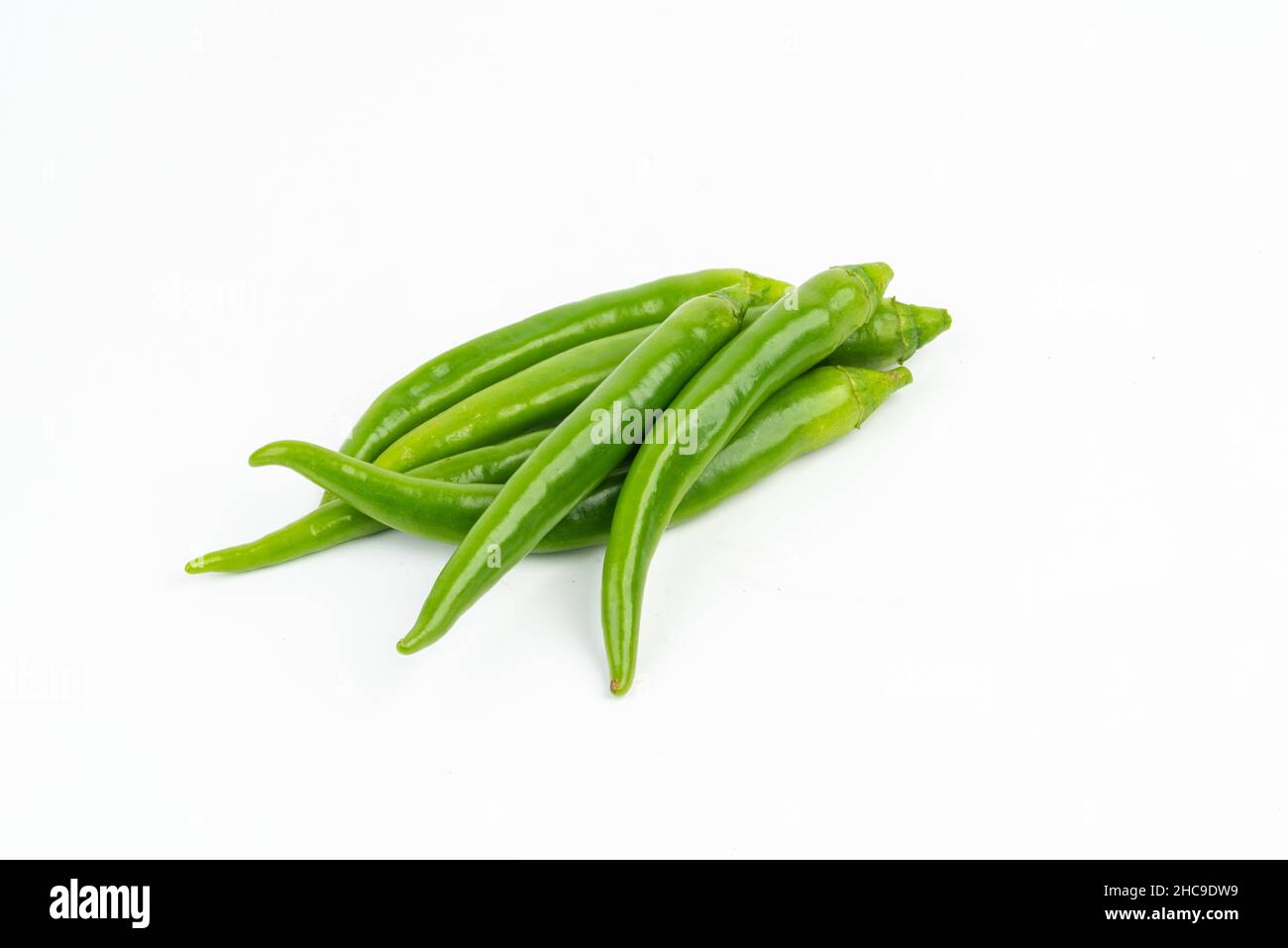 Piment vert en tas sur fond blanc isolé Banque D'Images